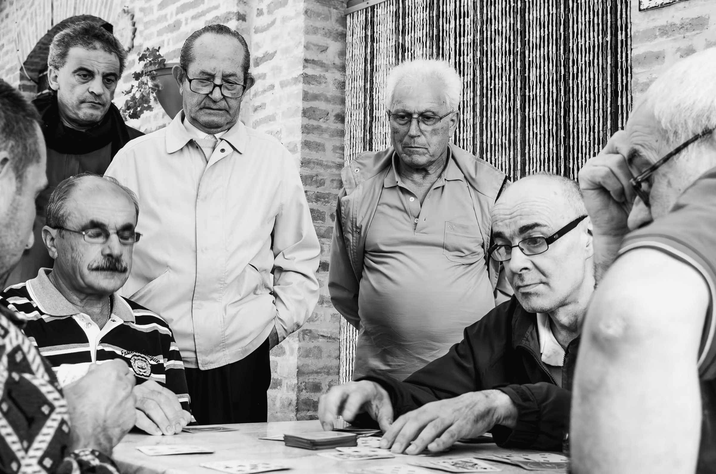 Card Game Camaraderie A group of older men playing cards.