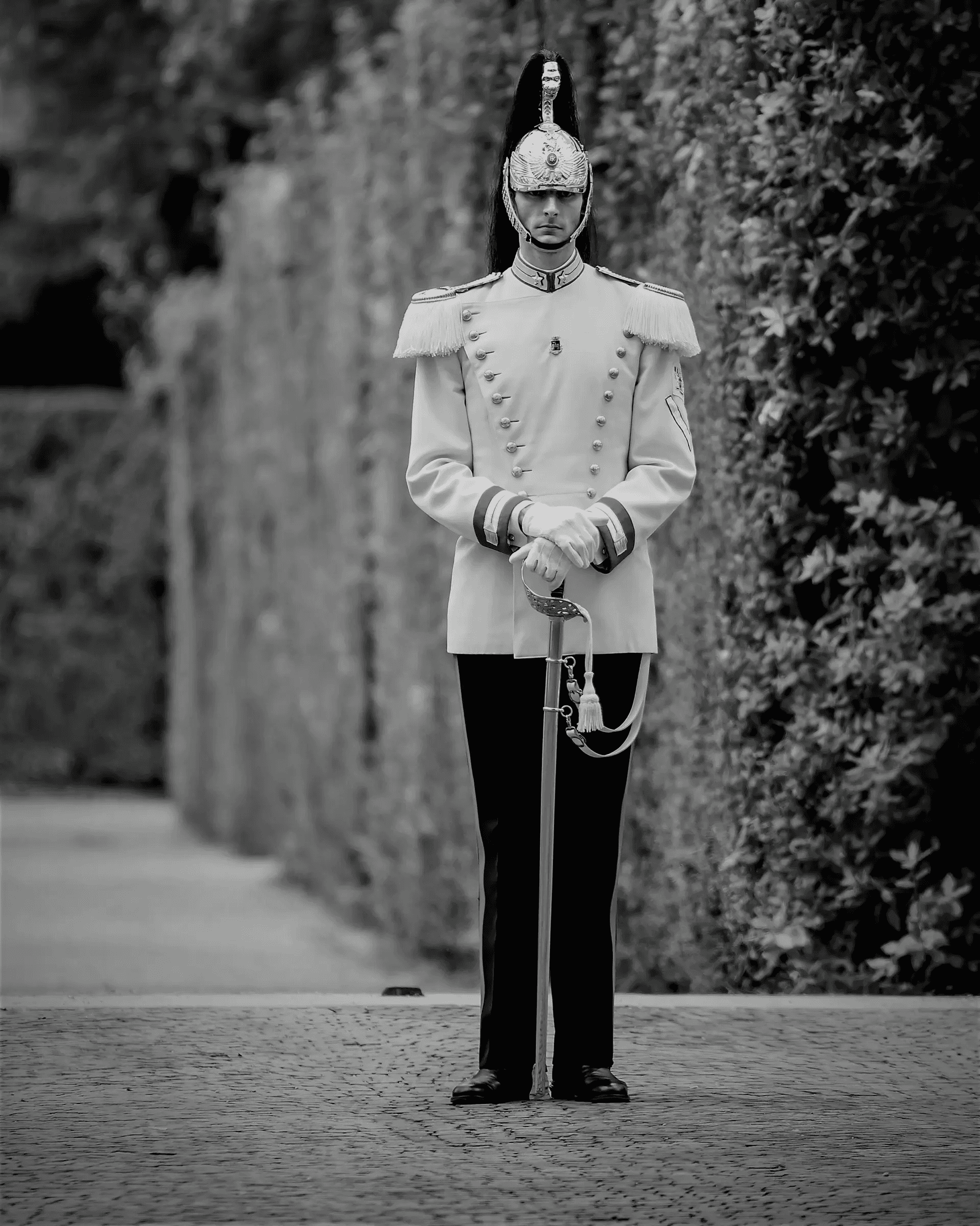 Black and white photograph of a Cuirassier standing at attention, guarding the Quirinal Palace in Rome, Italy.